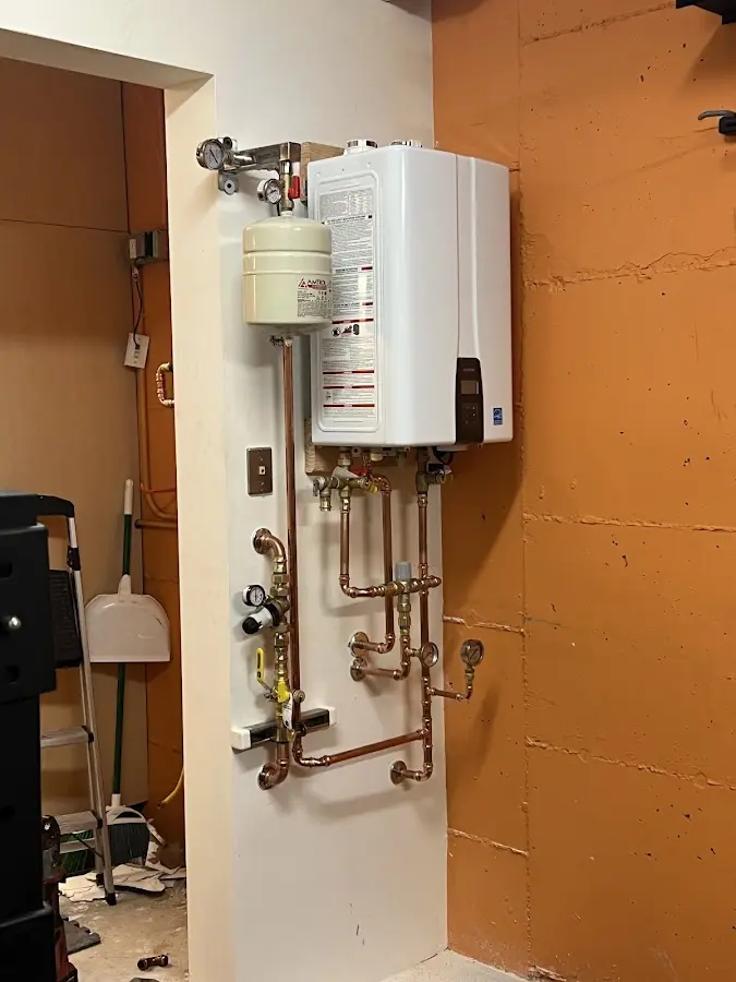 Plumbing technician inspecting water heater connections in Hereford